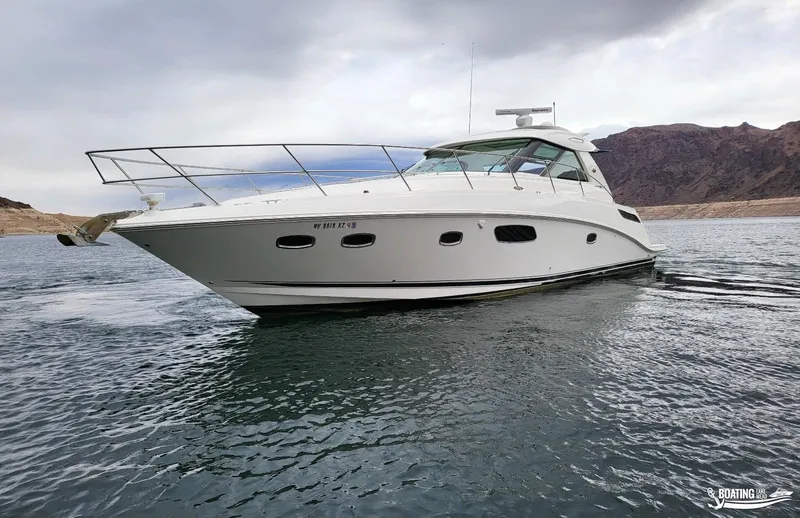 Slide: The Image of 2012 Sea Ray 450 Sundancer yacht cruising on a lake with mountainous background. - 9