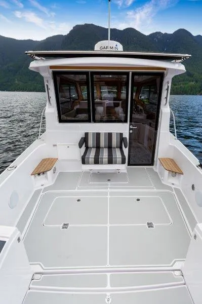 Slide: The Image of 2024 True North 34 boat with spacious deck and scenic mountain backdrop. - 13