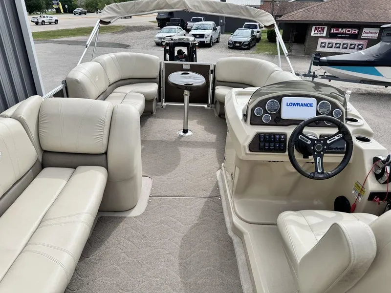 Slide: The Image of 2018 Starcraft 23 FD pontoon boat interior with beige seating and Lowrance navigation system. - 4