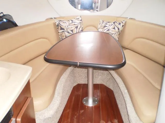 Slide: The Image of Interior of 2021 Crownline 264 CR boat with tan seating and wooden table. - 12