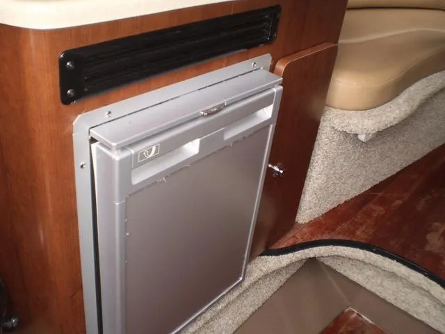 Slide: The Image of 2021 Crownline 264 CR cabin interior with built-in mini fridge. - 15