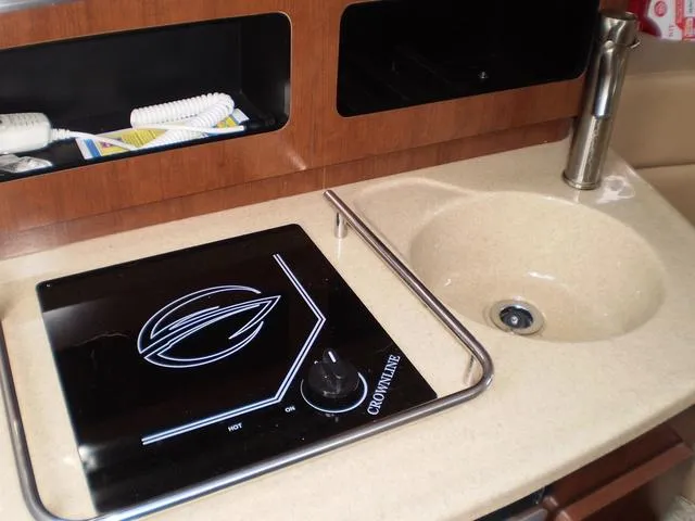 Slide: The Image of Crownline 264 CR 2021 boat kitchen with stove and sink. - 19