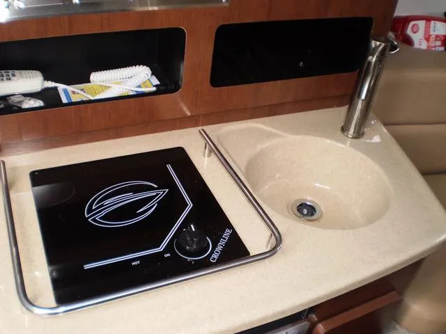 Slide: The Image of 2021 Crownline 264 CR boat kitchen with stove and sink. - 28