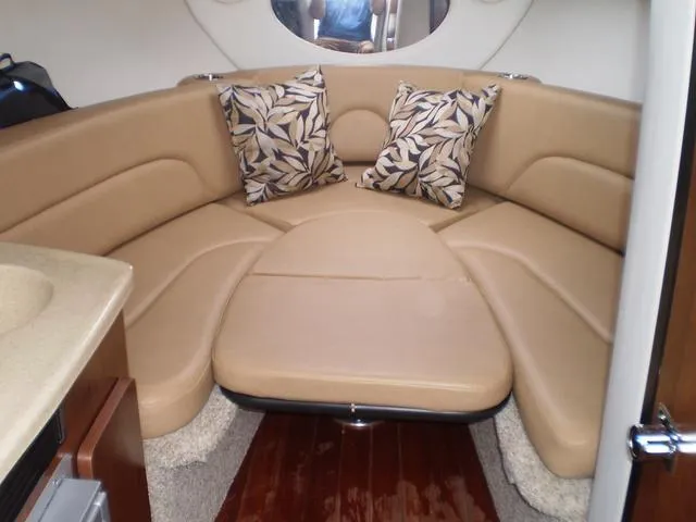 Slide: The Image of 2021 Crownline 264 CR cabin interior with beige seating and decorative pillows. - 30
