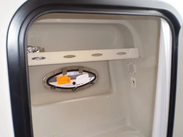Slide: The Image of 2021 Crownline 264 CR cabin interior with porthole window and storage shelf. - 37