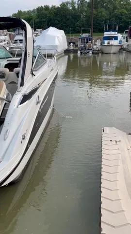 Slide: The Image of 2021 Crownline 264 CR boat docked in a marina with surrounding watercraft. - 46