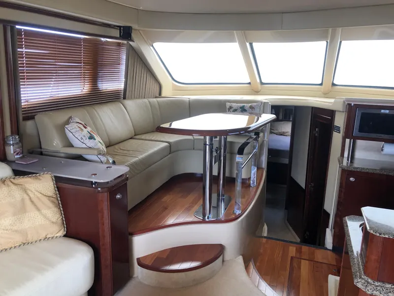 Slide: The Image of Interior of 2006 Sea Ray 52 Sedan Bridge yacht with leather seating and wooden accents. - 25