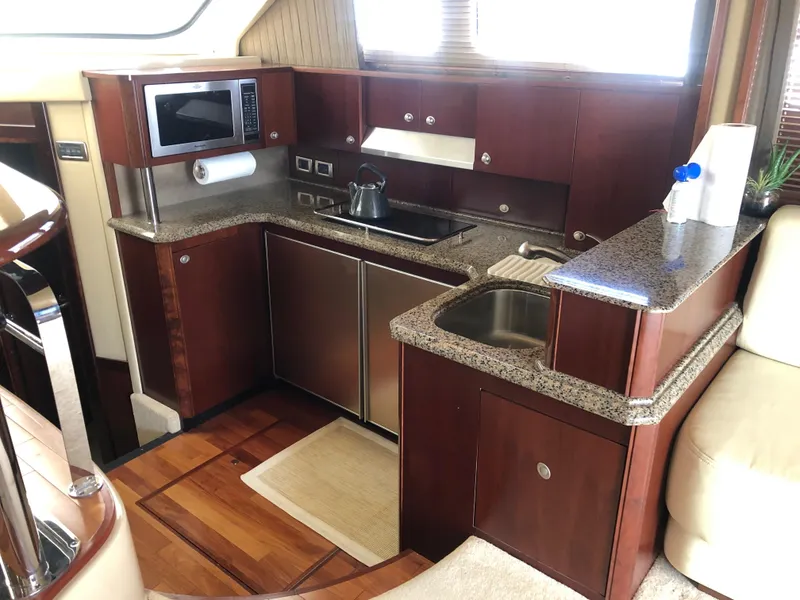 Slide: The Image of 2006 Sea Ray 52 Sedan Bridge yacht kitchen with modern appliances and wooden cabinetry. - 26
