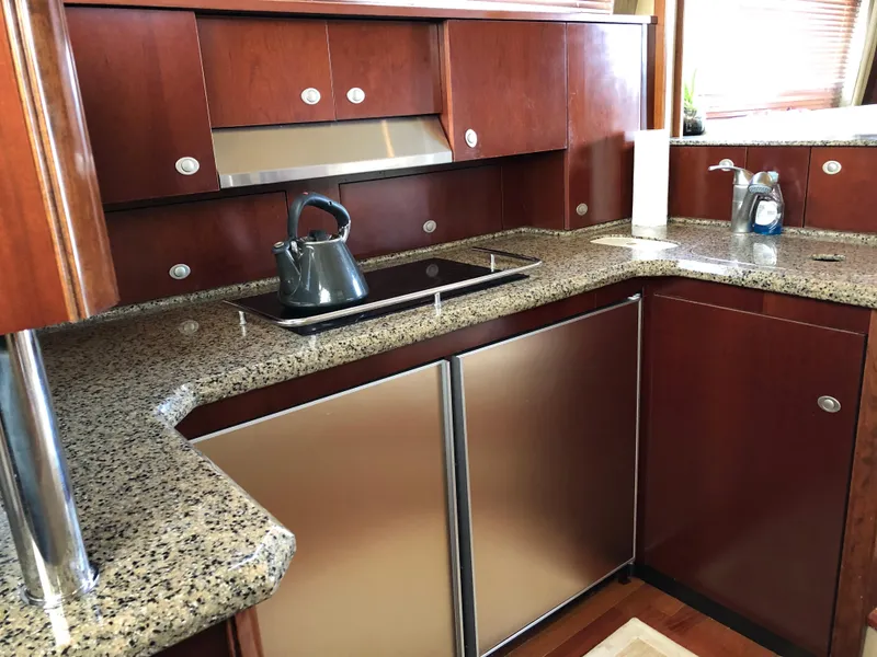Slide: The Image of 2006 Sea Ray 52 Sedan Bridge kitchen with granite countertops and stainless steel appliances. - 27