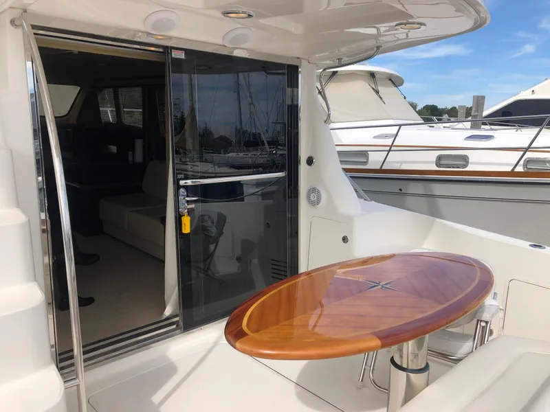 Slide: The Image of 2006 Sea Ray 52 Sedan Bridge yacht with polished wood table and sliding glass door. - 6