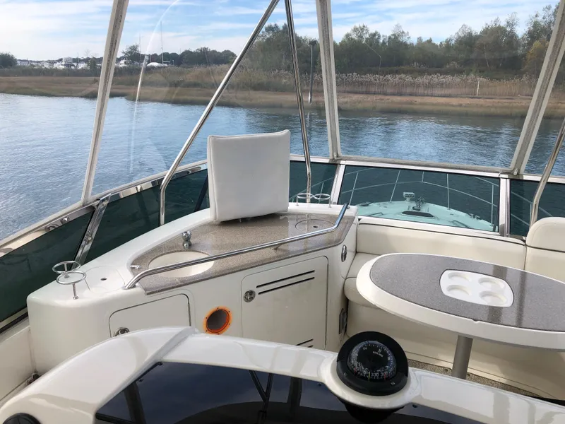 Slide: The Image of 2006 Sea Ray 52 Sedan Bridge yacht interior with helm, seating, and water view. - 9