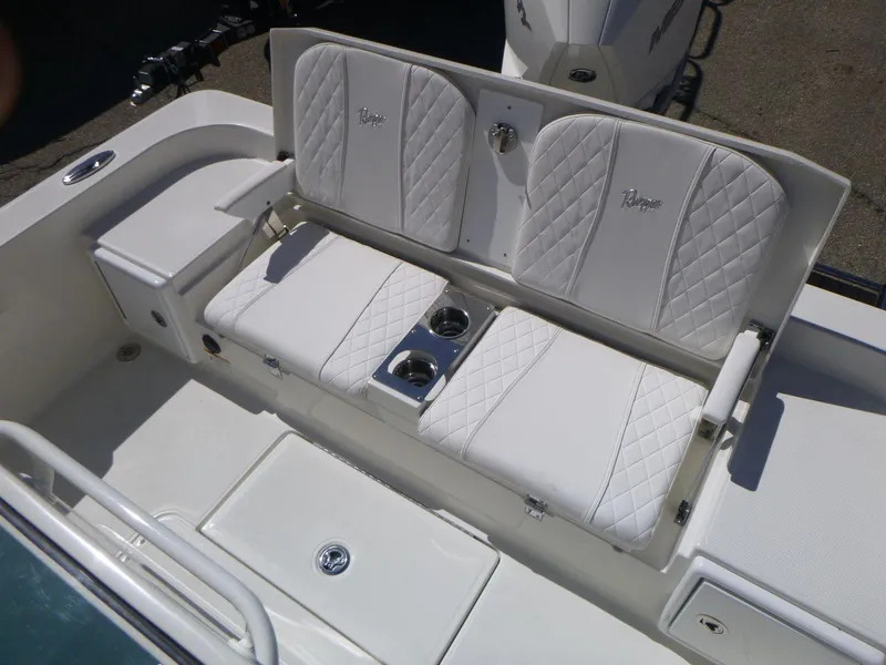Slide: The Image of 2024 Ranger 2360 Bay boat with white cushioned seating and cup holders. - 14