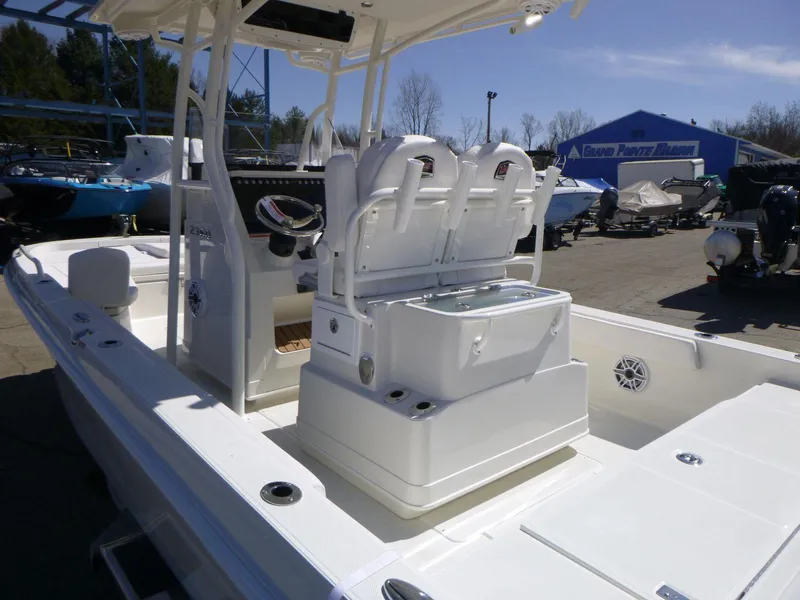 Slide: The Image of 2024 Ranger 2360 Bay boat interior with seating and console, parked outdoors. - 15