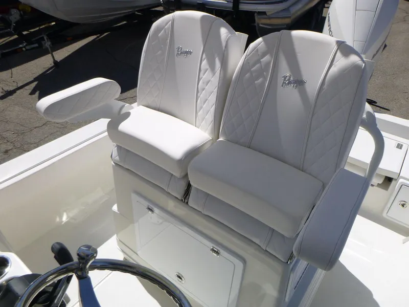 Slide: The Image of 2024 Ranger 2360 Bay boat with white cushioned seats and steering wheel. - 6