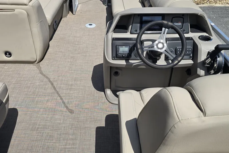 Slide: The Image of 2024 Sun Tracker Party Barge 24 DLX interior with steering console and beige seating. - 55