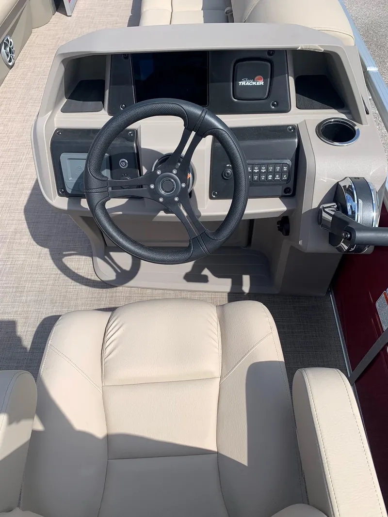 Slide: The Image of 2024 Sun Tracker Party Barge 24 DLX helm with steering wheel and control panel. - 4