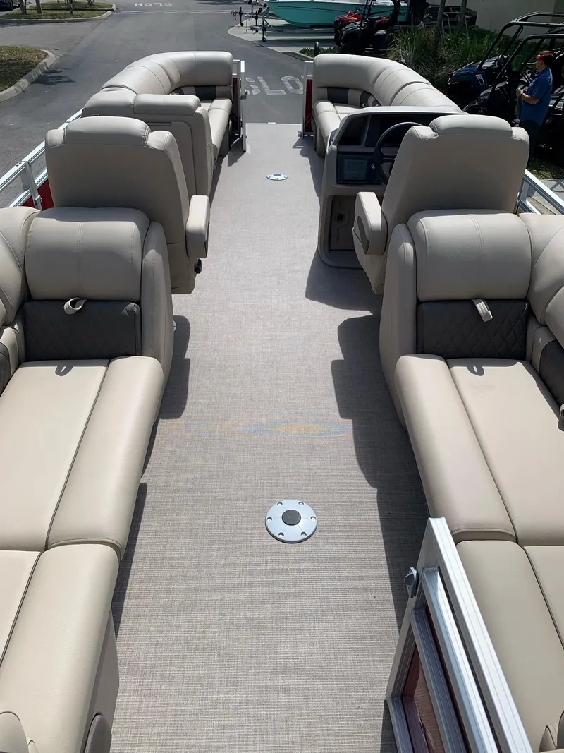 Slide: The Image of 2024 Sun Tracker Party Barge 24 DLX interior with beige seating and spacious layout. - 5