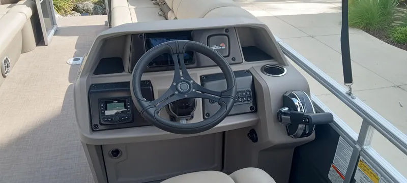 Slide: The Image of 2024 Sun Tracker Party Barge 24 DLX steering console with controls and navigation equipment. - 3