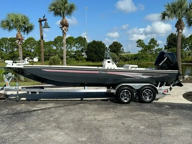 The Image of 2024 Ranger RB210 boat on trailer, parked outdoors under clear sky. - 0