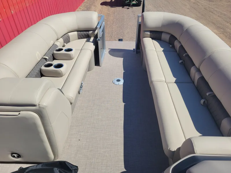 Slide: The Image of 2024 Sun Tracker Party Barge 24 DLX interior with beige seating and cup holders. - 5