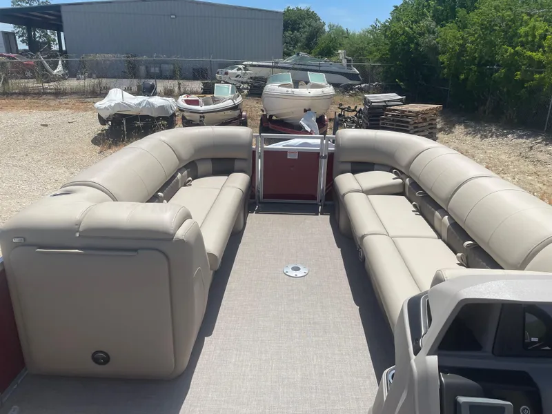 Slide: The Image of 2024 Sun Tracker Party Barge 24 DLX with spacious seating, parked outdoors. - 6