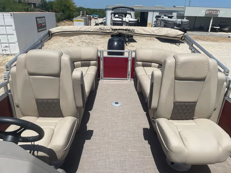 Slide: The Image of 2024 Sun Tracker Party Barge 24 DLX with beige seating and spacious deck layout. - 8