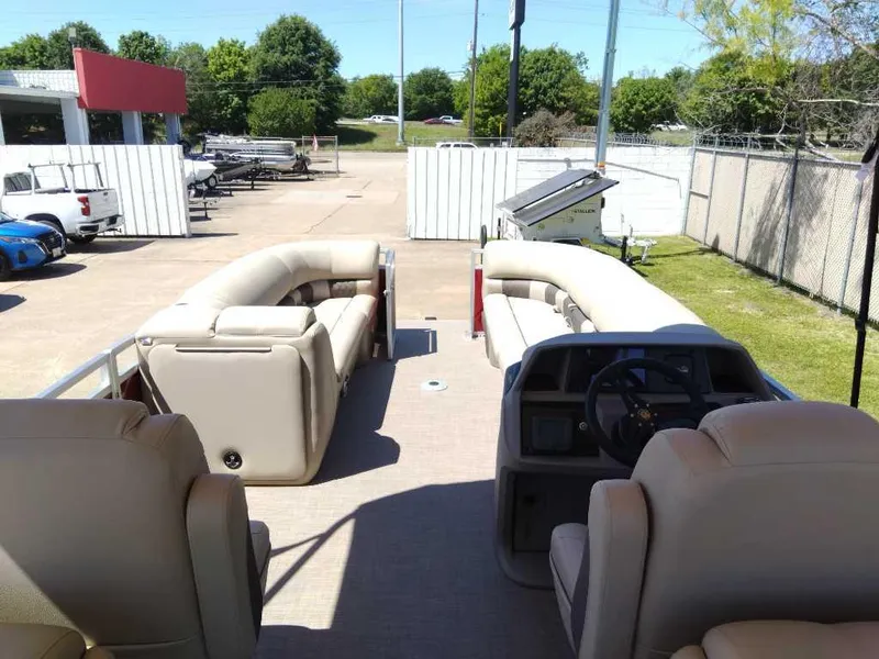 Slide: The Image of 2024 Sun Tracker Party Barge 24 DLX pontoon boat interior with beige seating and steering console. - 7