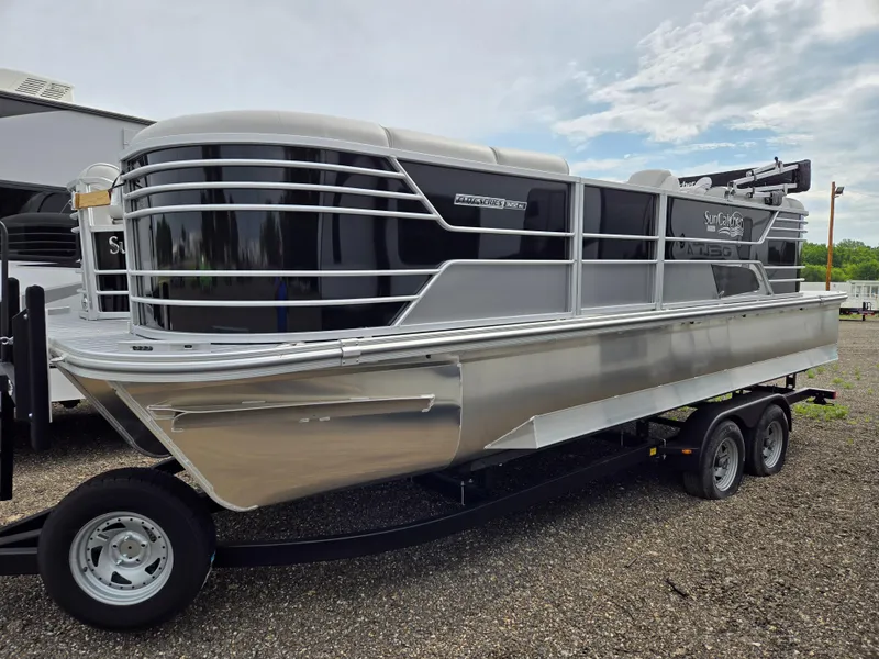 Slide: The Image of 2023 SunCatcher Elite 322 RC pontoon boat on a trailer, parked outdoors. - 0
