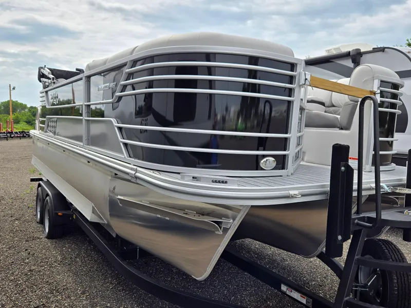 Slide: The Image of 2023 SunCatcher Elite 322 RC pontoon boat on trailer, sleek design, outdoor setting. - 4