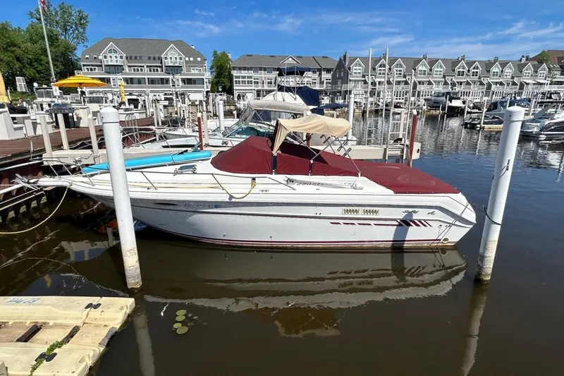 Slide: The Image of 1992 Sea Ray 280 Weekender docked at a marina with waterfront homes. - 12