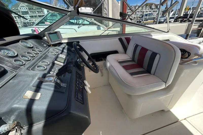 Slide: The Image of 1992 Sea Ray 280 Weekender cockpit with steering wheel and striped seating. - 5