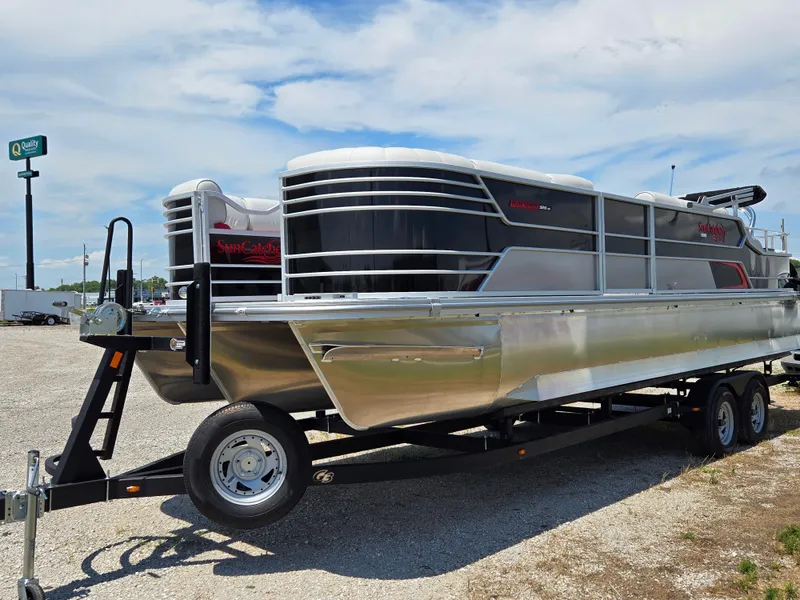 Slide: The Image of 2024 SunCatcher Elite 326 SS pontoon boat on a trailer, parked outdoors. - 6