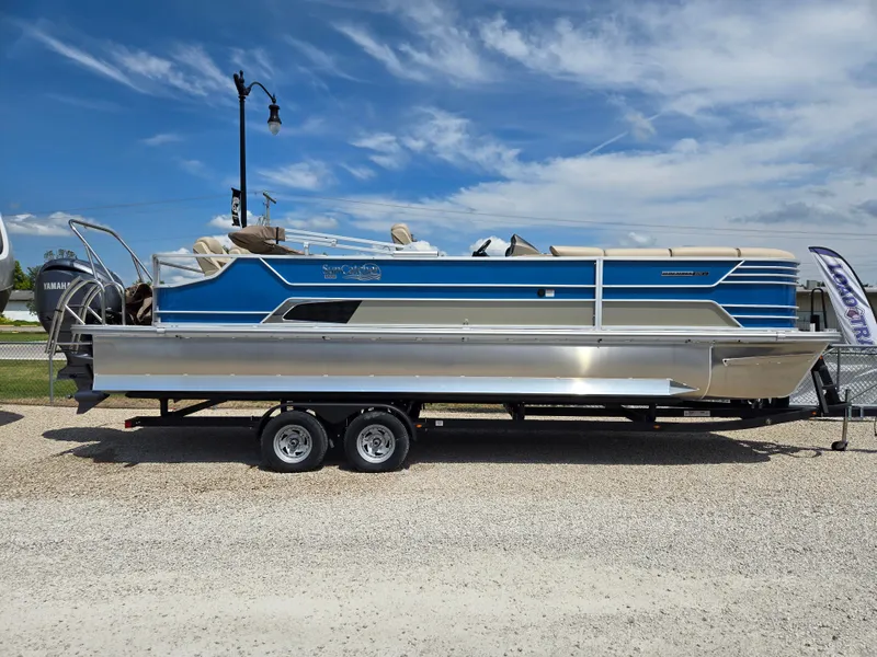 Slide: The Image of 2024 SunCatcher Elite 326 SE pontoon boat on trailer, blue and silver design. - 0