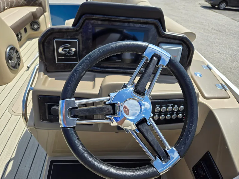 Slide: The Image of 2024 SunCatcher Elite 326 SE boat steering wheel and dashboard controls. - 11