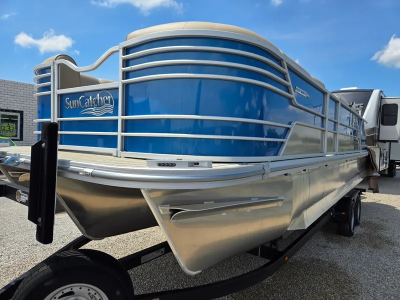 Slide: The Image of 2024 SunCatcher Elite 326 SE pontoon boat on trailer, blue and silver design. - 6