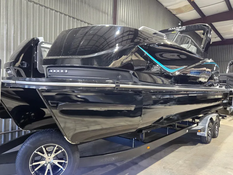 Slide: The Image of 2024 SunCatcher Amara boat in a showroom, sleek black design on a trailer. - 1