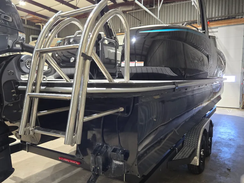 Slide: The Image of 2024 SunCatcher Amara boat in a warehouse, featuring a sleek black design and stainless steel ladder. - 5