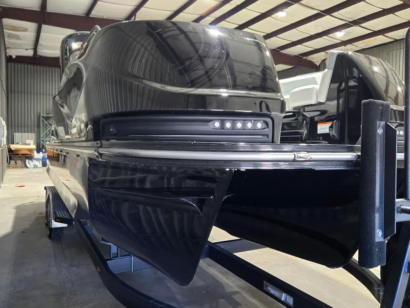 Slide: The Image of 2024 SunCatcher Amara boat in a warehouse, showcasing sleek black design and modern features. - 6