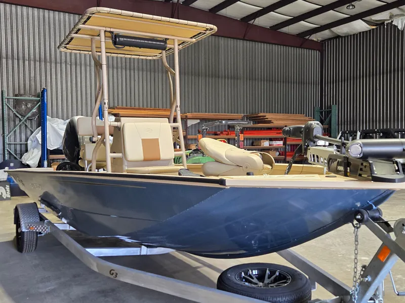 Slide: The Image of 2023 G3 Bay 20 GX boat in a warehouse, on a trailer, with a trolling motor. - 6