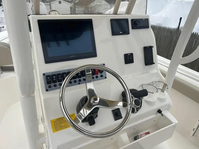 Slide: The Image of 2024 Key West 219 FS boat console with steering wheel and electronic controls. - 17