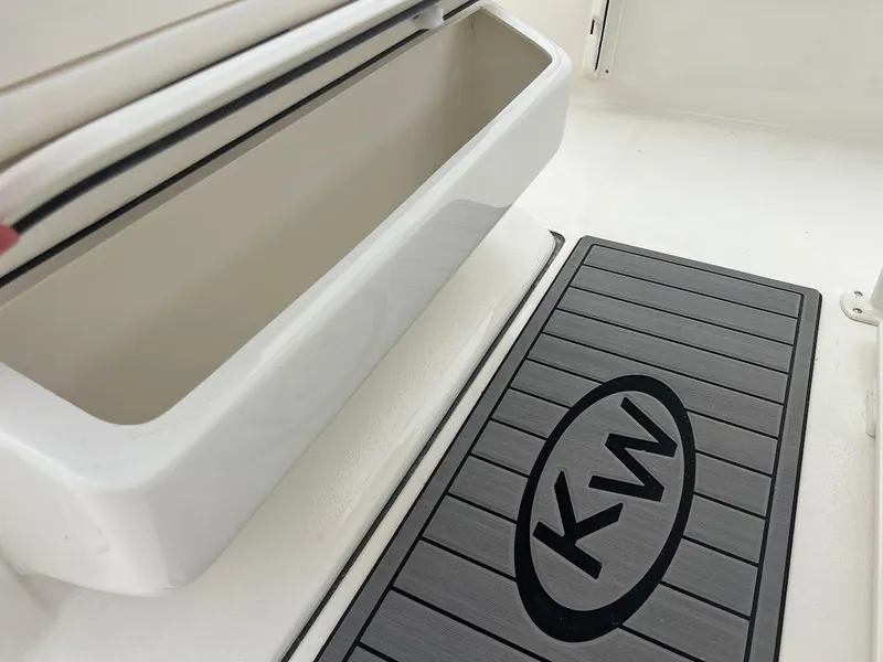 Slide: The Image of 2024 Key West 219 FS boat interior storage compartment and KW logo mat. - 18