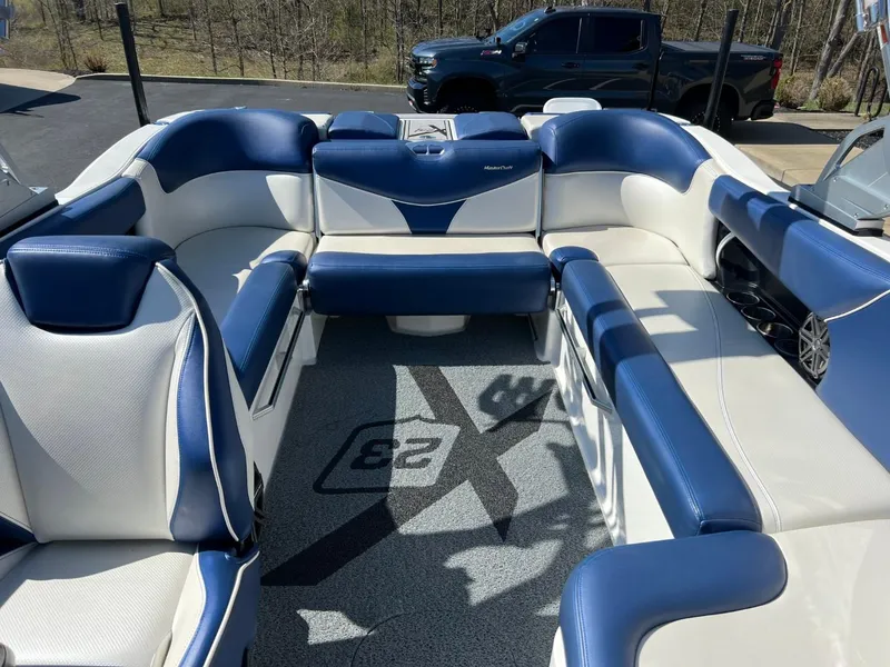 Slide: The Image of 2016 MasterCraft X23 boat interior with blue and white seating. - 10