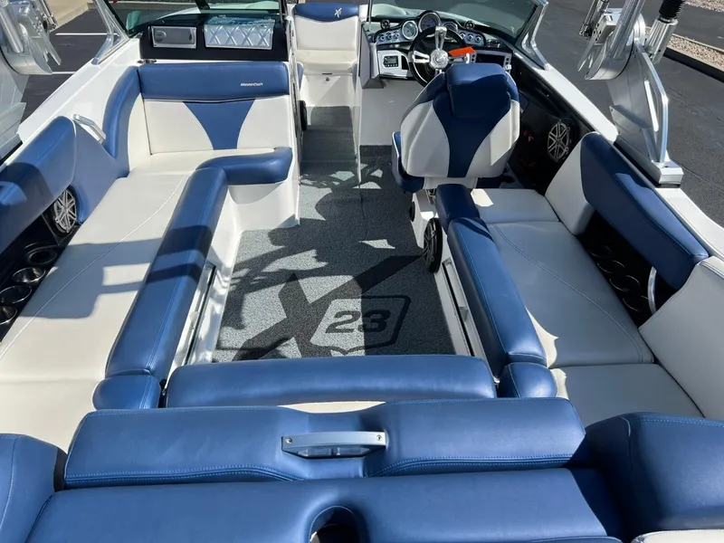 Slide: The Image of 2016 MasterCraft X23 boat interior with blue and white seating. - 11