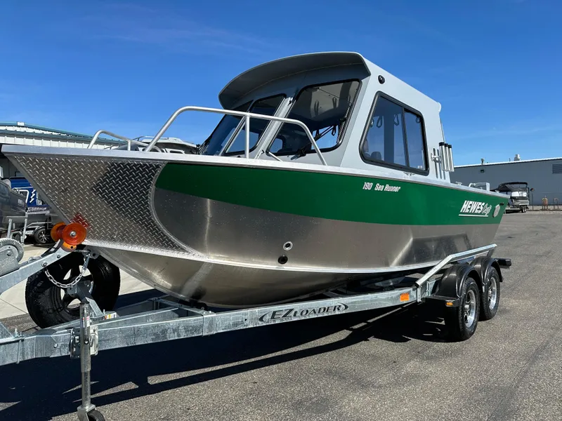 The Image of 2024 Hewescraft 190 Searunner HT FC boat on trailer, green and silver exterior. - 0