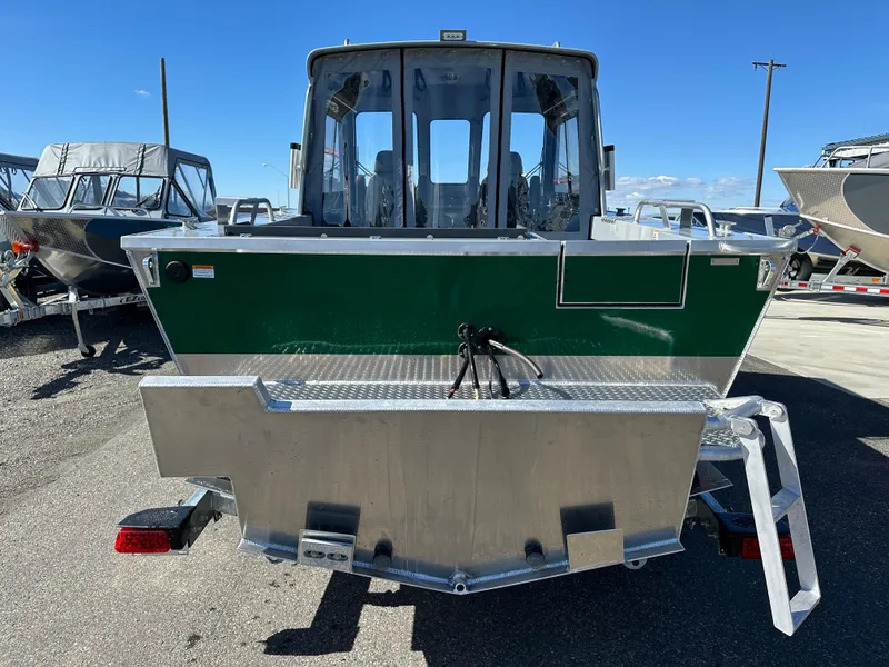 Slide: The Image of 2024 Hewescraft 190 Searunner HT FC boat, rear view, green and silver, parked outdoors. - 3