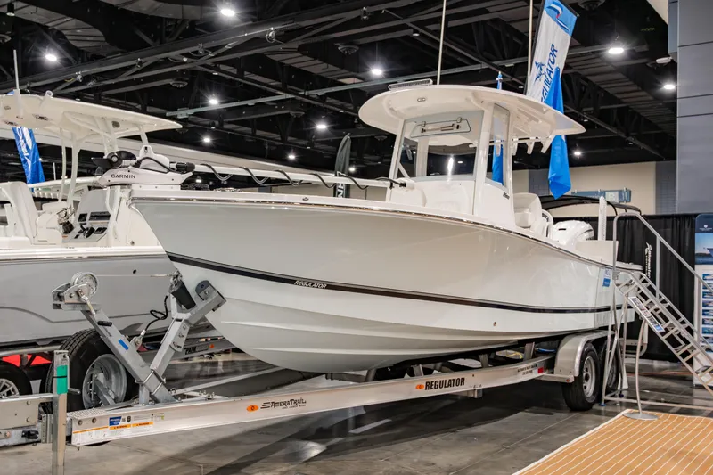 Slide: The Image of 2025 Regulator 26XO boat displayed indoors on a trailer. - 1