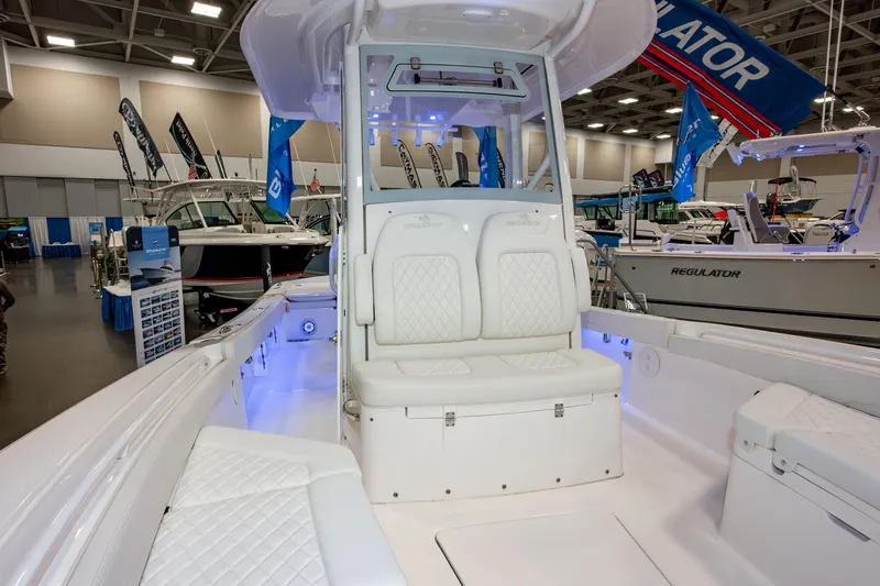 Slide: The Image of 2025 Regulator 26XO boat interior at a boat show, featuring white seating and modern design. - 11
