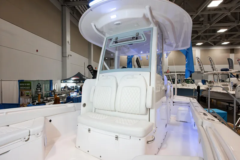 Slide: The Image of 2025 Regulator 26XO boat interior at a boat show, featuring white seating and modern design. - 12