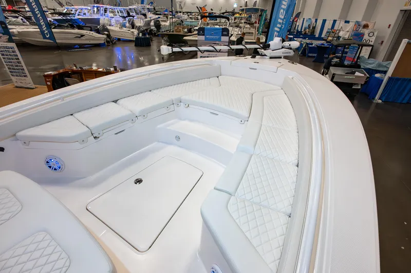 Slide: The Image of 2025 Regulator 26XO boat interior with white cushioned seating at a boat show. - 13