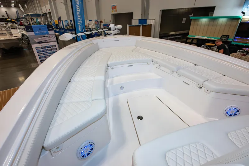 Slide: The Image of 2025 Regulator 26XO boat interior with white cushioned seating at a boat show. - 14